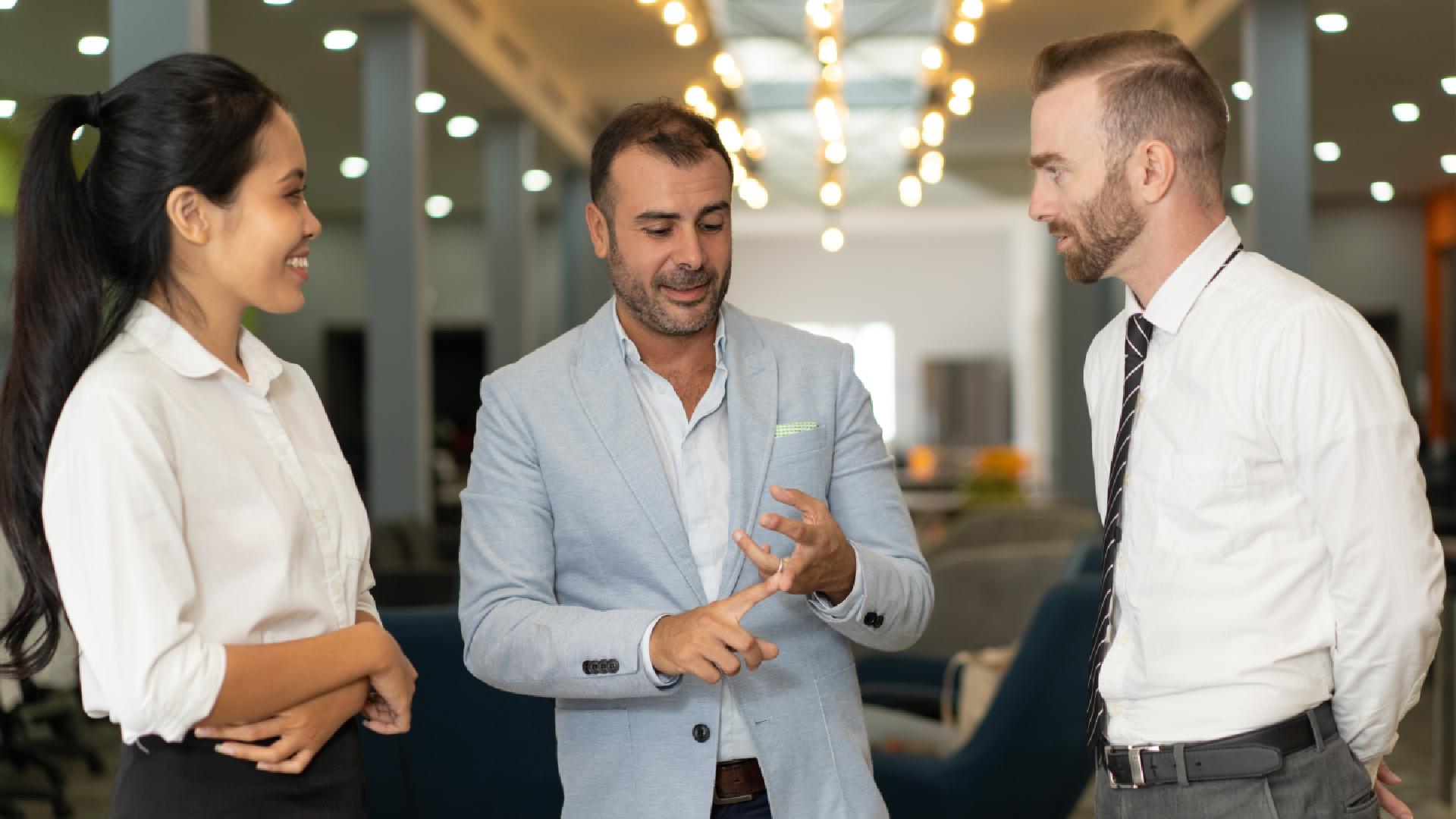 three-positive-business-people-talking-office-lobby